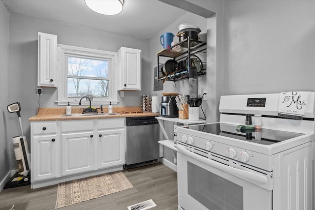 kitchen featuring white range with electric cooktop, white cabinets, a sink, light wood-type flooring, and dishwasher