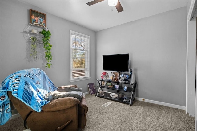 living area with ceiling fan, baseboards, and carpet flooring