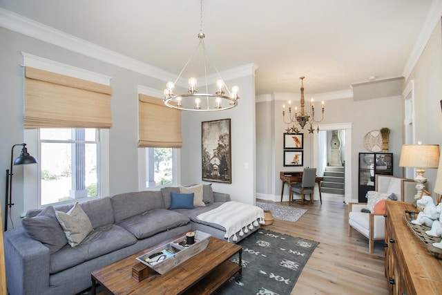 living area featuring an inviting chandelier, light wood-style flooring, ornamental molding, and baseboards