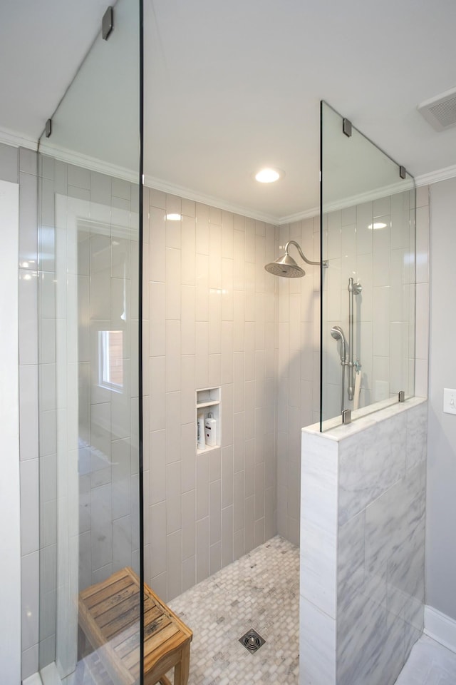 full bath featuring ornamental molding, visible vents, and walk in shower