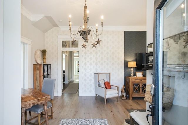 interior space featuring a notable chandelier, ornamental molding, wood finished floors, baseboards, and wallpapered walls