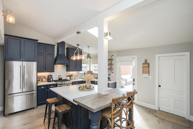 kitchen featuring vaulted ceiling, stainless steel appliances, a breakfast bar, and custom exhaust hood