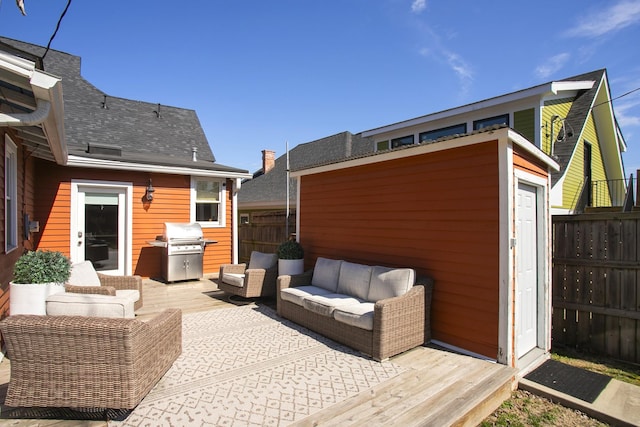 view of patio / terrace with a grill, fence, outdoor lounge area, and an outbuilding