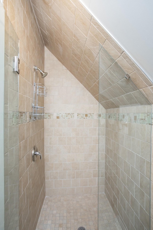 full bathroom featuring lofted ceiling and a tile shower