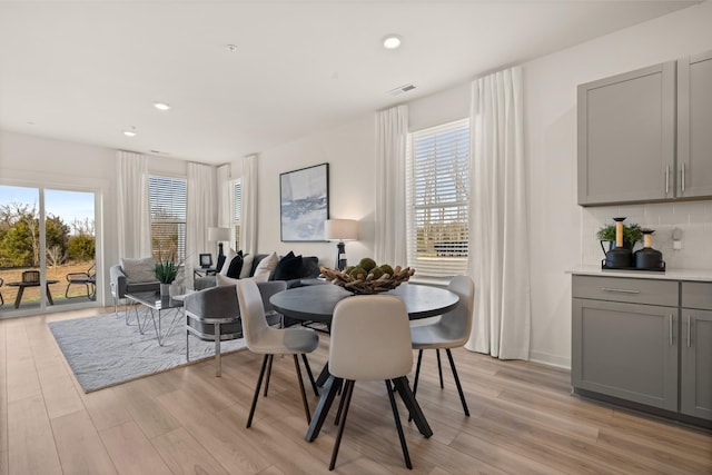 dining space featuring visible vents, plenty of natural light, and light wood-style flooring