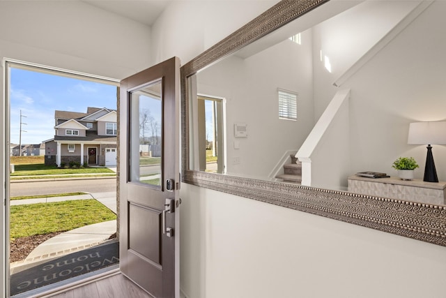 entrance foyer with stairs, a wealth of natural light, and wood finished floors