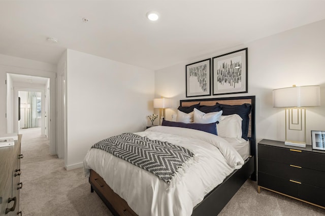 bedroom with baseboards and light colored carpet