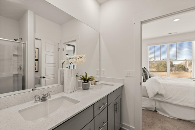 ensuite bathroom featuring a stall shower, a sink, ensuite bath, and double vanity