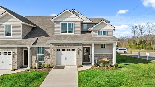 craftsman house featuring concrete driveway, brick siding, a front yard, and a shingled roof