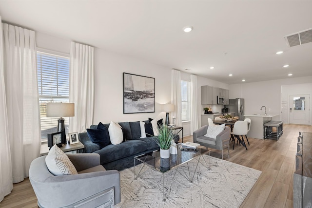 living room with visible vents, recessed lighting, light wood-style flooring, and a healthy amount of sunlight