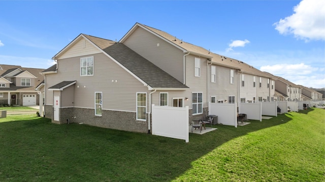 rear view of house with a residential view, brick siding, a yard, and fence