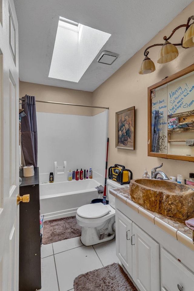 bathroom with tile patterned flooring, toilet, a skylight, vanity, and shower / bathing tub combination