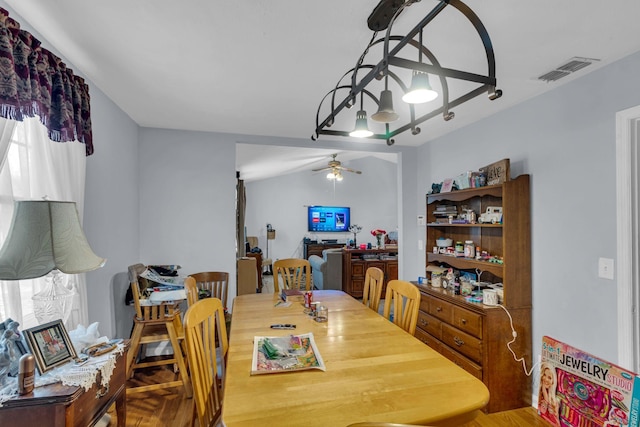 dining room featuring lofted ceiling, visible vents, and ceiling fan