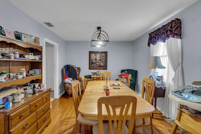 dining room featuring visible vents, a notable chandelier, and light wood finished floors