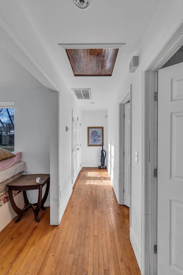 hallway featuring light wood-type flooring and baseboards