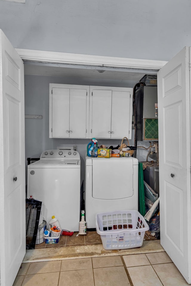 laundry area with light tile patterned floors, cabinet space, and washer and dryer