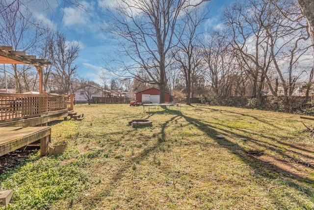 view of yard featuring fence, a deck, and an outdoor structure