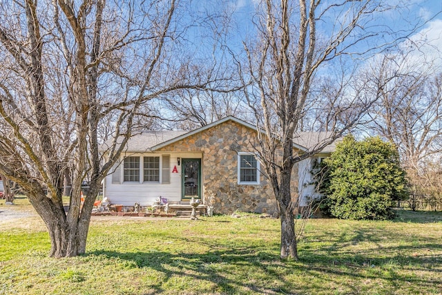 view of front of home featuring stone siding and a front yard