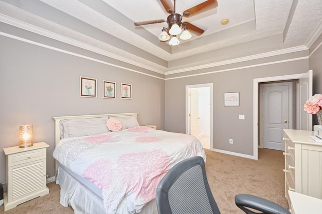 bedroom featuring light carpet, baseboards, connected bathroom, a tray ceiling, and crown molding