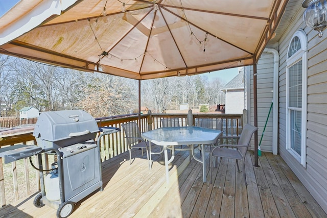 wooden terrace featuring outdoor dining space and area for grilling