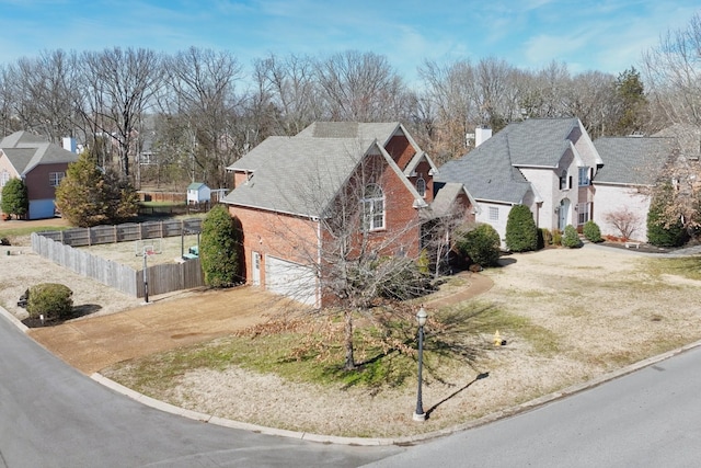 view of front facade with brick siding, fence, and an attached garage