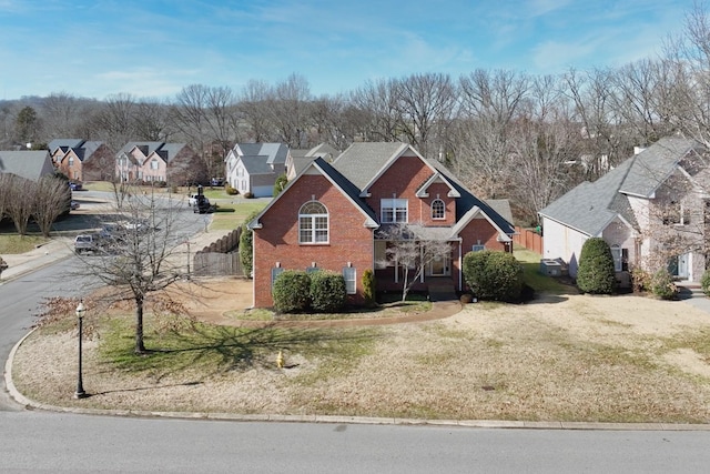 traditional home featuring brick siding, a front lawn, and a residential view