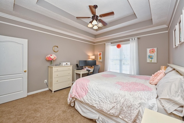 bedroom with a tray ceiling, crown molding, light carpet, ceiling fan, and baseboards