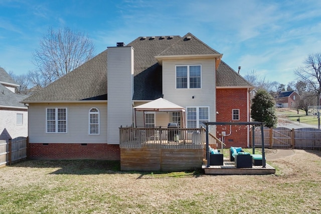 rear view of property featuring a yard, a chimney, crawl space, a fenced backyard, and a wooden deck