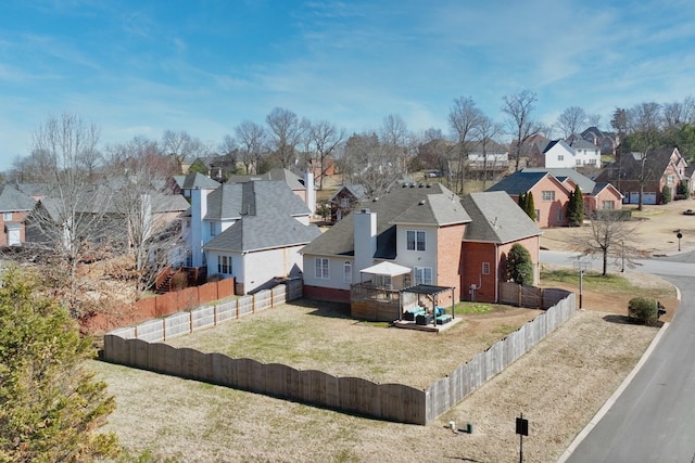 view of front of property with a deck, a front yard, a fenced backyard, and a residential view