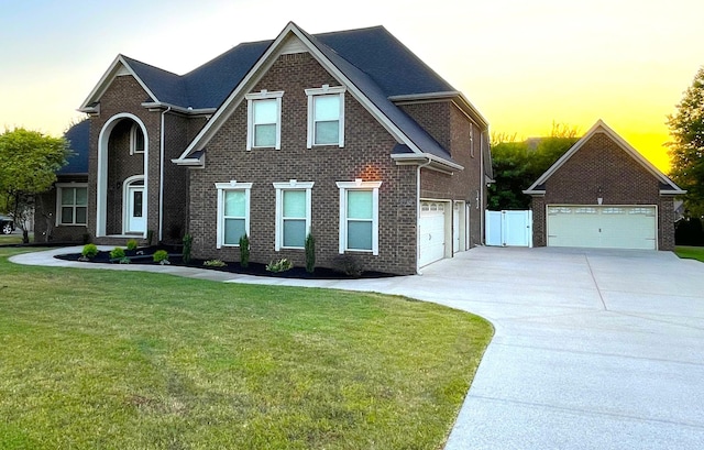 view of front facade featuring a garage, brick siding, fence, and a front yard