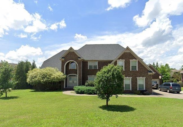 view of front of property with a front lawn and brick siding