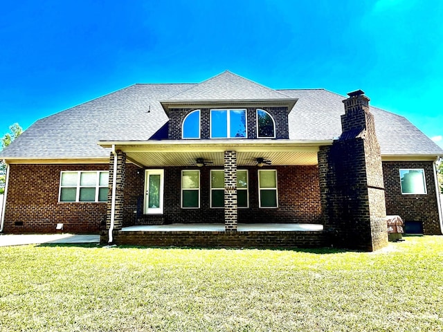 view of front of home with brick siding, a patio, a shingled roof, a ceiling fan, and a front yard