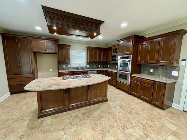 kitchen with appliances with stainless steel finishes, a center island, a sink, and baseboards