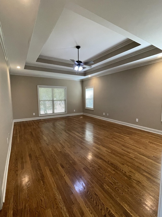 unfurnished room with dark wood-type flooring, a raised ceiling, and baseboards