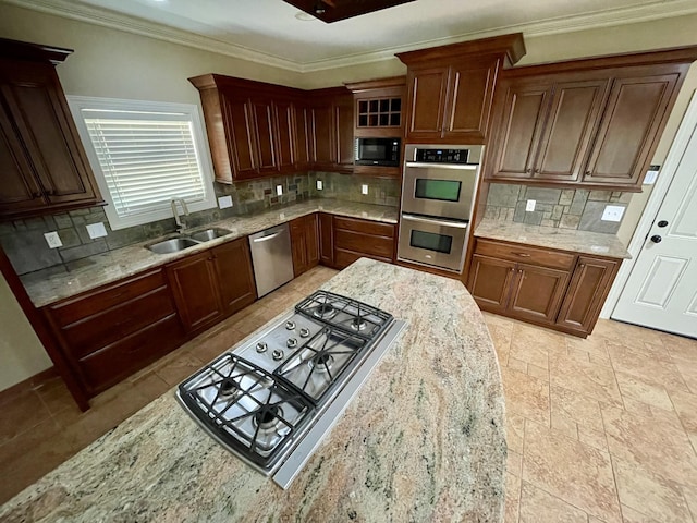 kitchen with light stone countertops, decorative backsplash, stainless steel appliances, and a sink