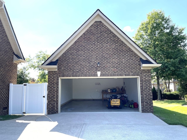 garage featuring concrete driveway and a gate