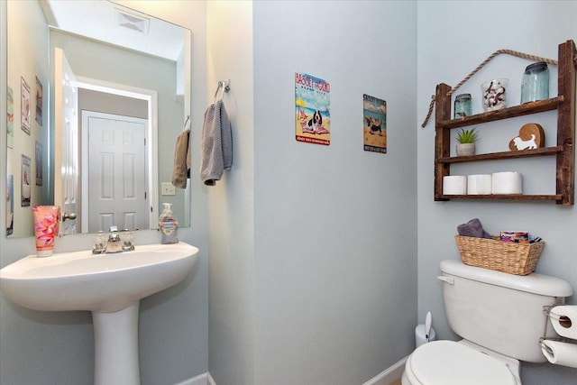 bathroom with baseboards, visible vents, and toilet