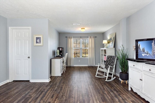 unfurnished room featuring a textured ceiling, dark wood finished floors, visible vents, and baseboards