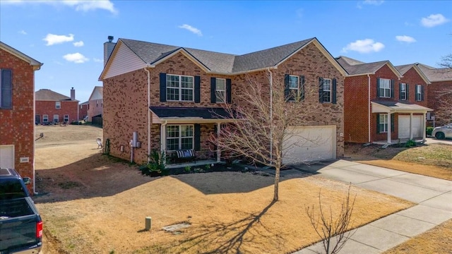 traditional-style home featuring driveway, brick siding, a porch, and an attached garage