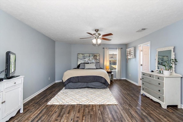 bedroom with dark wood-style floors, visible vents, a ceiling fan, a textured ceiling, and baseboards