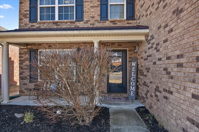 view of exterior entry with brick siding