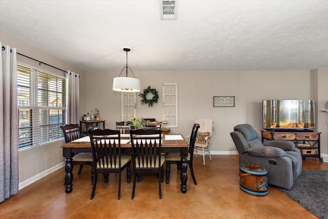 dining room with visible vents, a textured ceiling, and baseboards