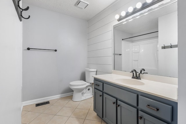 bathroom with a textured ceiling, toilet, vanity, visible vents, and tile patterned floors