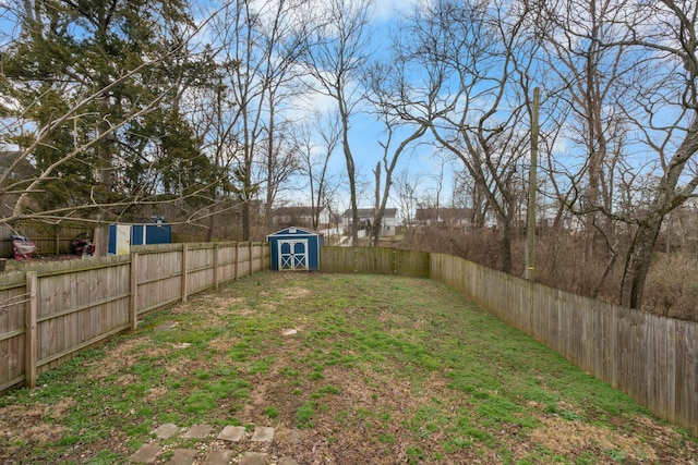 view of yard featuring an outbuilding, a fenced backyard, and a storage unit