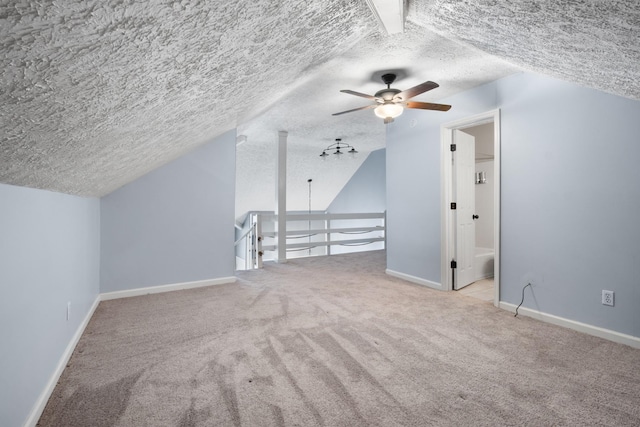 bonus room with baseboards, a ceiling fan, lofted ceiling, a textured ceiling, and carpet flooring