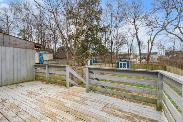 deck featuring a fenced backyard, an outdoor structure, and a storage unit