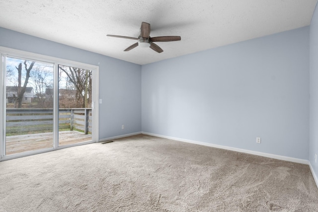 unfurnished room with a textured ceiling, a ceiling fan, visible vents, baseboards, and carpet