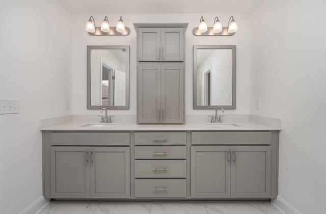 full bathroom with marble finish floor, double vanity, and a sink