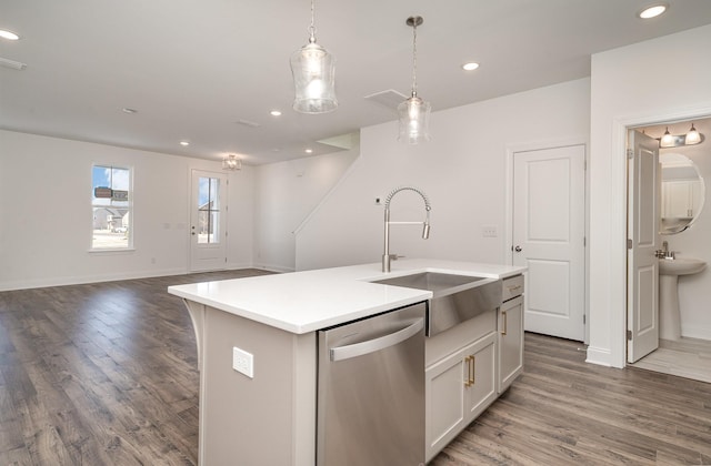 kitchen featuring a sink, light countertops, dishwasher, and wood finished floors