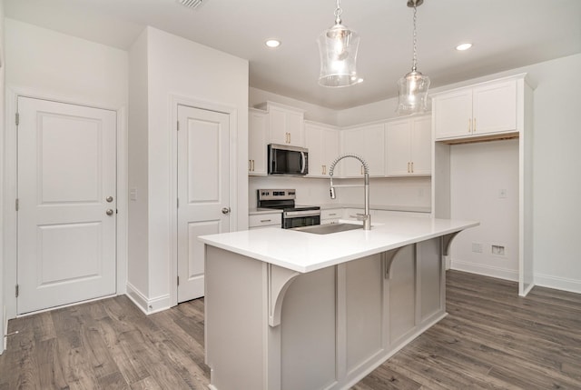 kitchen with white cabinetry, appliances with stainless steel finishes, dark wood-style flooring, and a sink